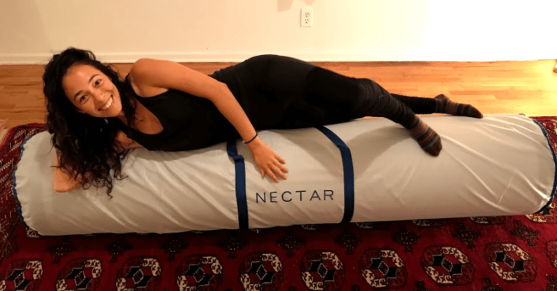 woman lying on top of still rolled up Nectar mattress