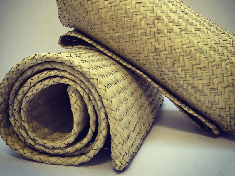 Two rolled up handwoven petate mats