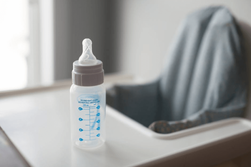 An empty baby bottle on a high chair