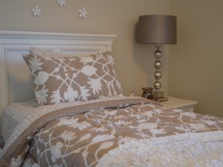 Bed next to nightstand with bedside lamp